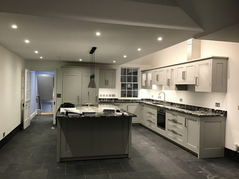 Kitchen Renovation Modern kitchen with grey cabinets, central island, and bright lighting.